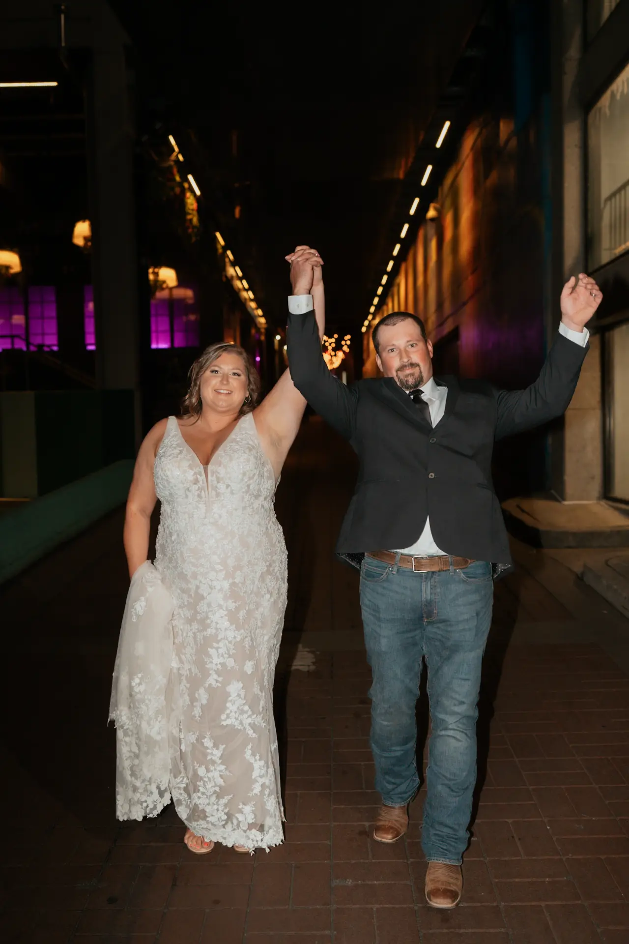 Sam and Justin celebrating with raised hands after their Wheatland, Iowa reception