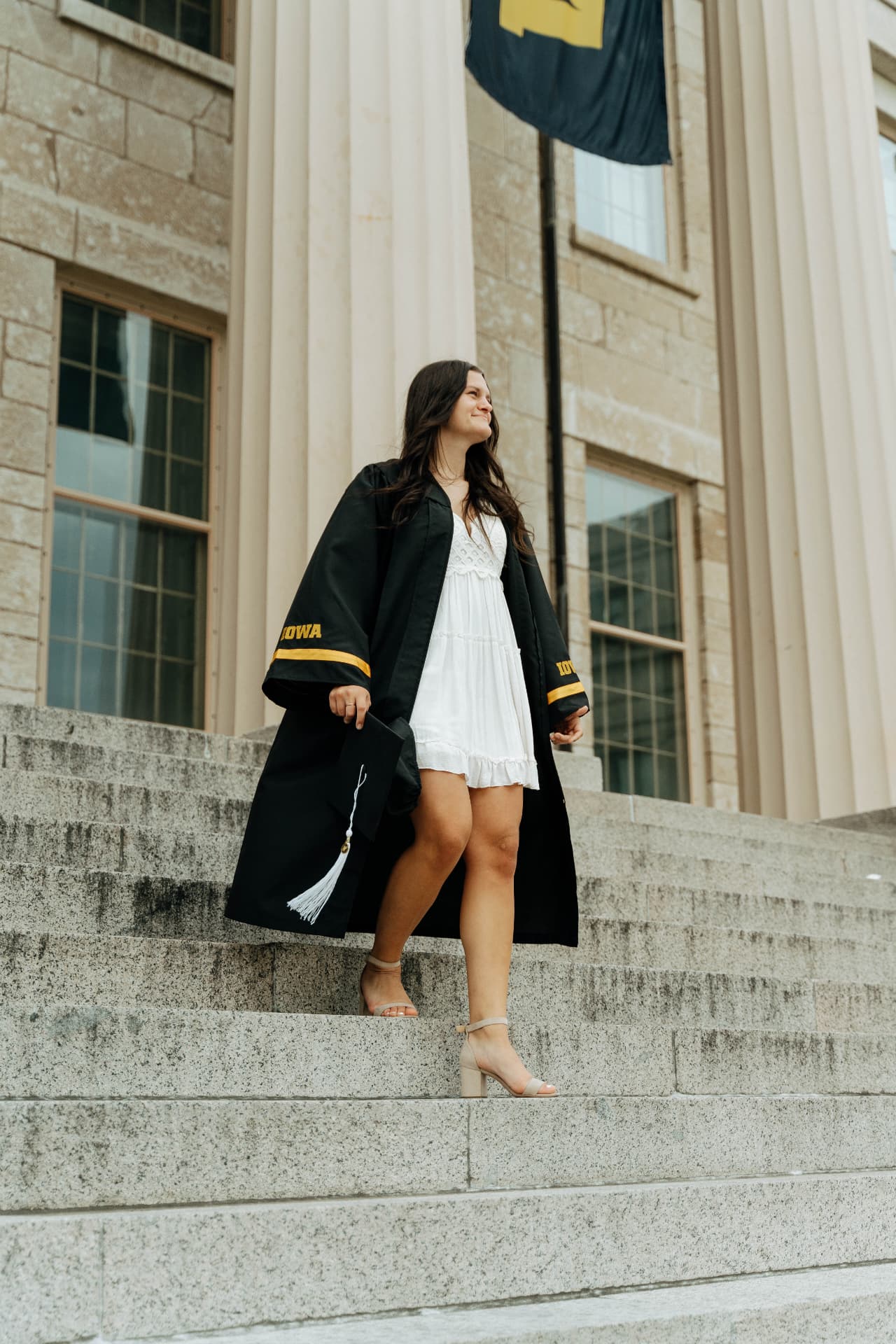 University of Iowa graduate on the Old Capitol steps in cap and gown